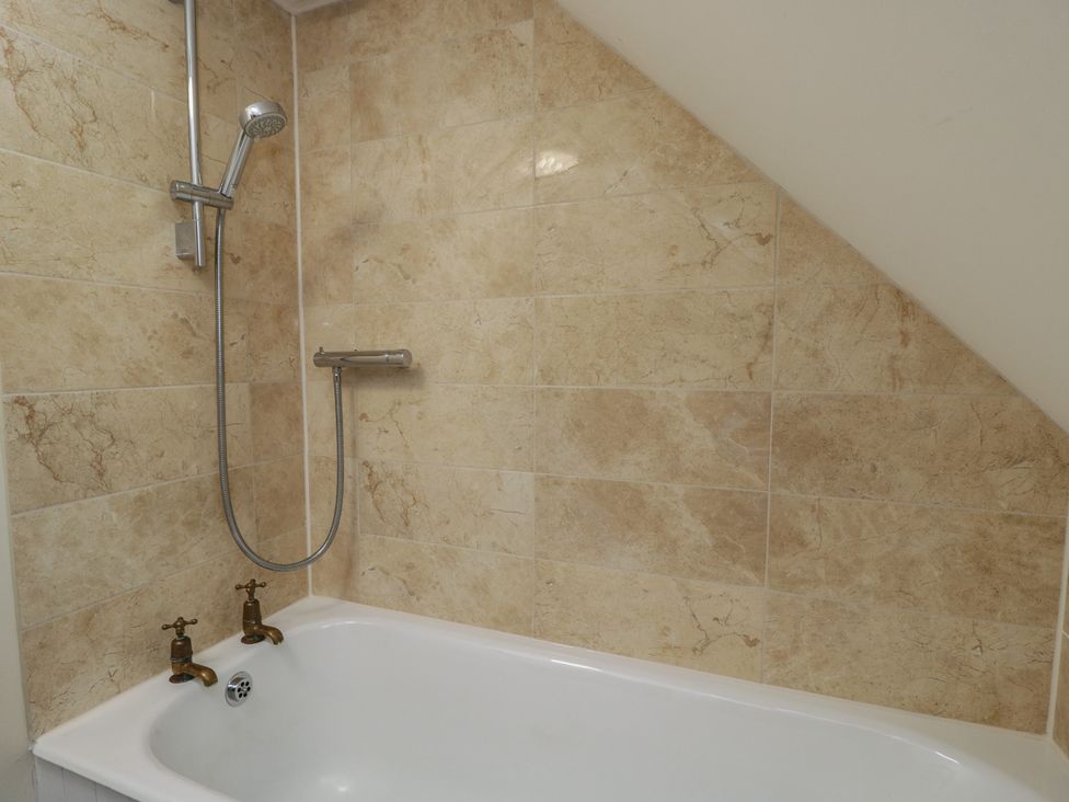 A bathroom with a bathtub and shower installed at Gardeners Hill Annex