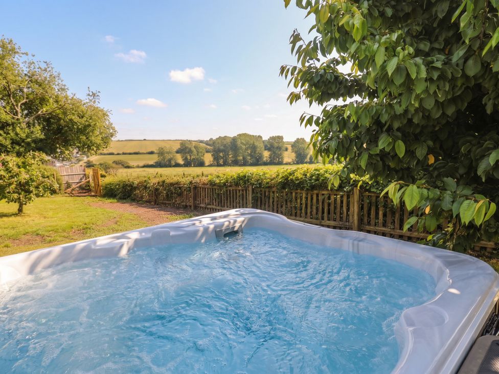 A garden with a hot tub and view of the field at The Old Inn Winterborne Whitechurch