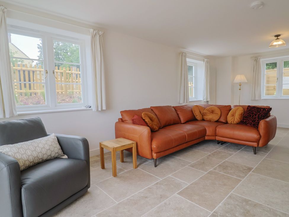 A living room with a sofa and a chair at The Old Inn in Winterborne Whitechurch