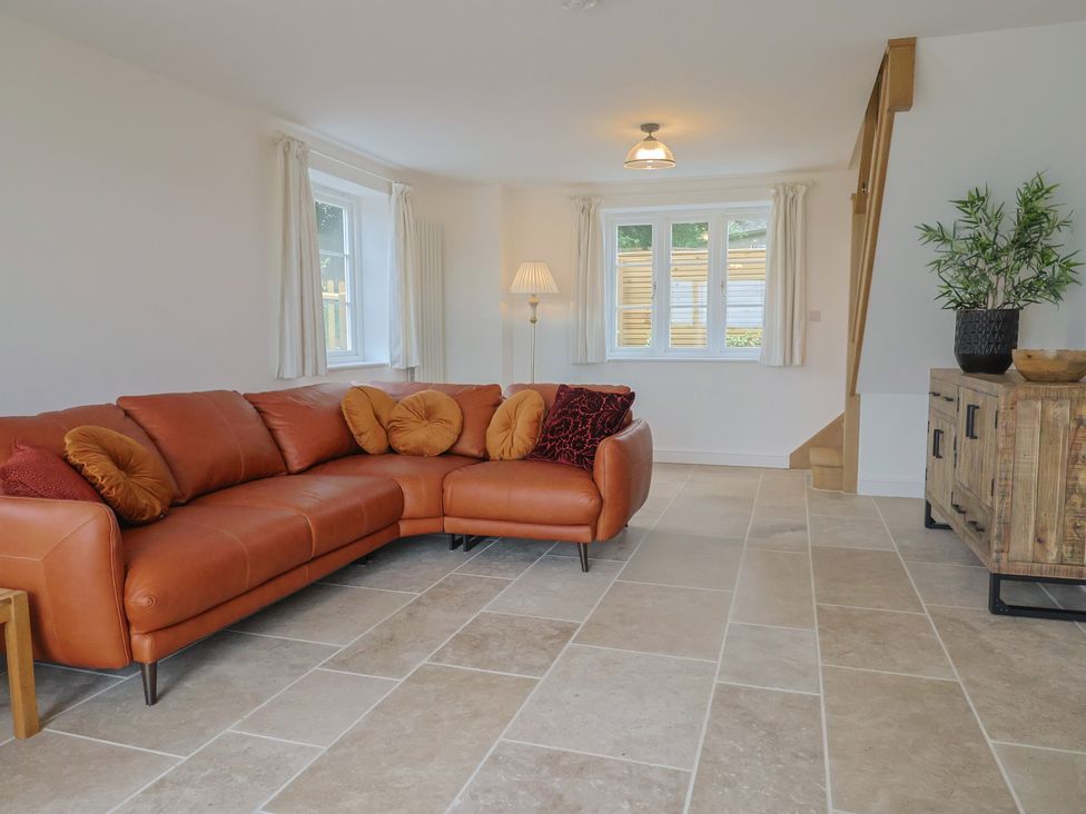 A living room with a sofa and lamp at The Old Inn in Winterborne Whitechurch