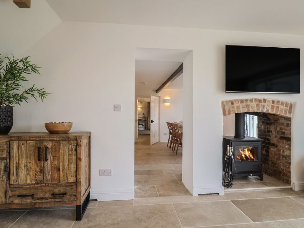 A living room with a fireplace and television at The Old Inn in Winterborne Whitechurch