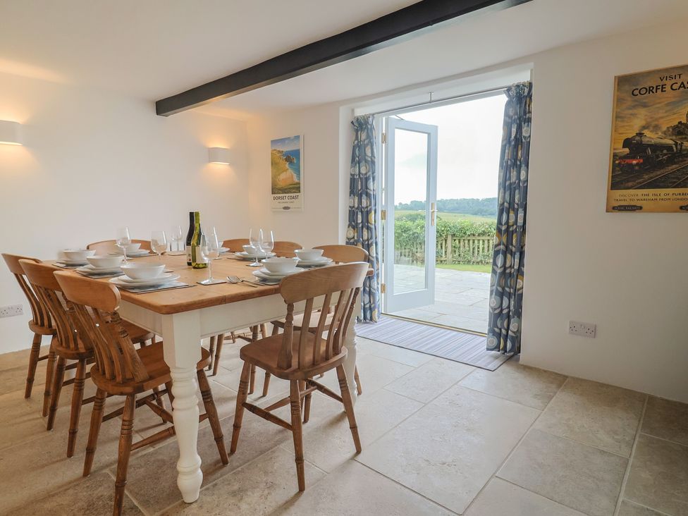A dining room with a table set for dinner at The Old Inn in Winterborne Whitechurch