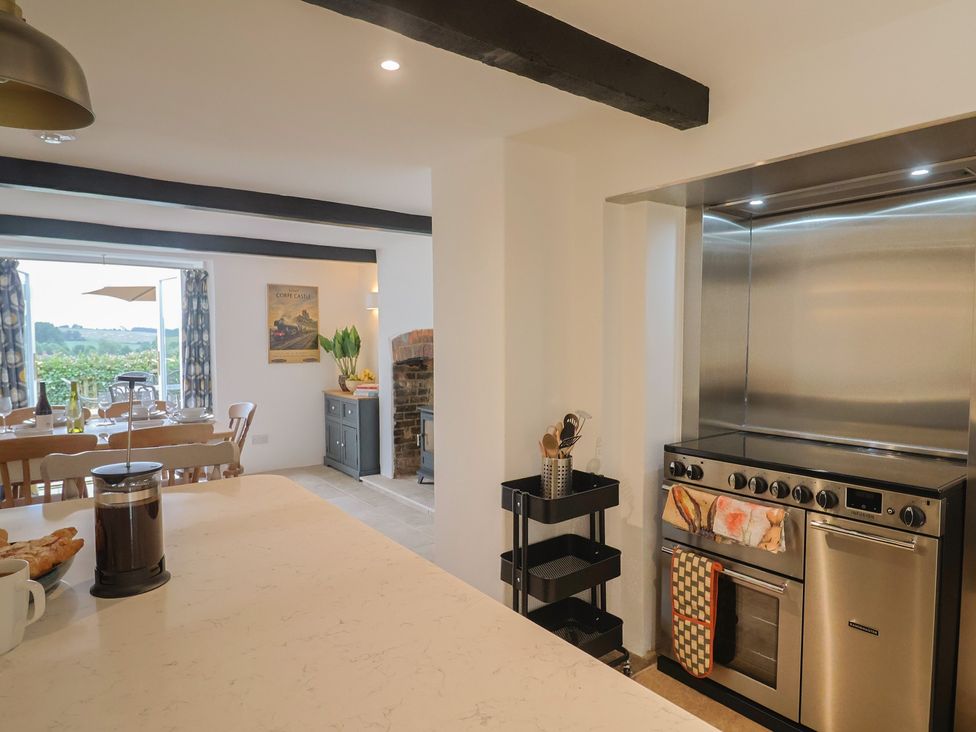 A kitchen with a dining table and stainless steel appliances at The Old Inn in Winterborne Whitechurch