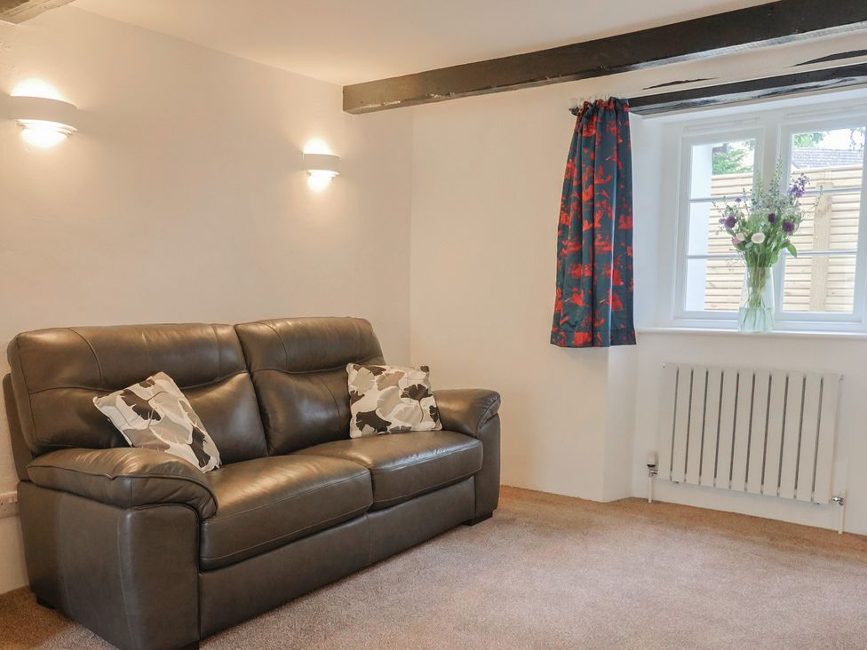 A living room with a sofa and a window at The Old Inn in Winterborne Whitechurch