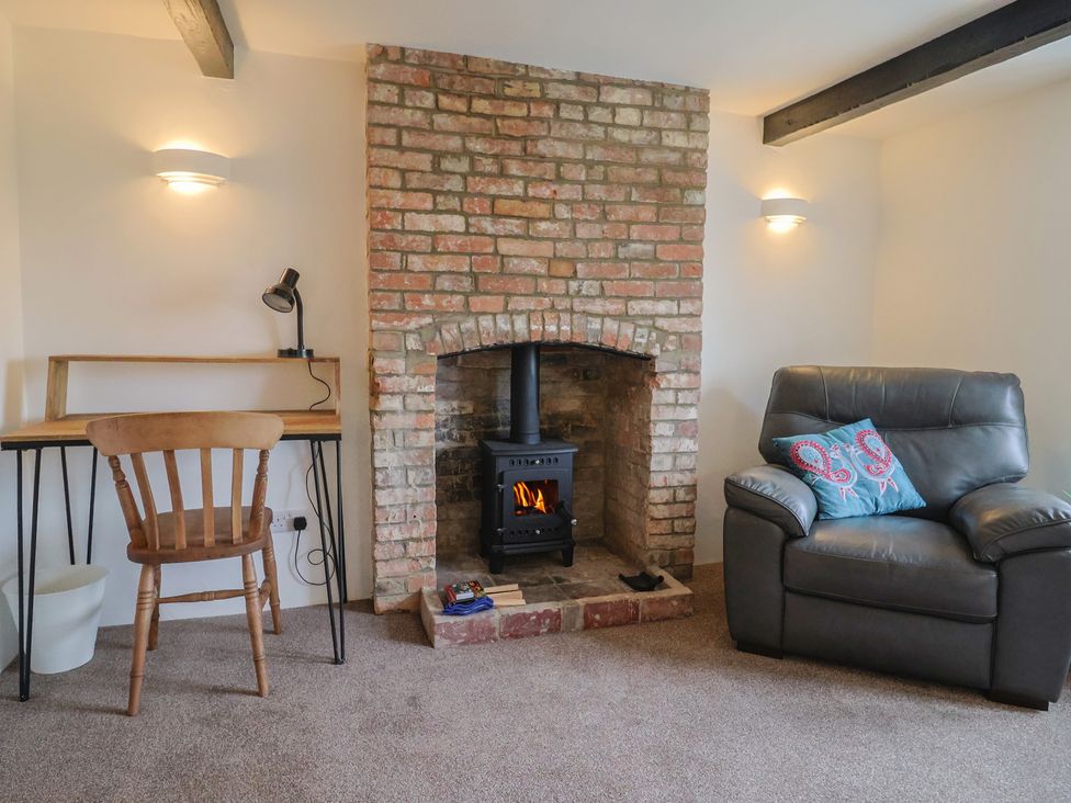 A living room with a fireplace and seating area at The Old Inn in Winterborne Whitechurch