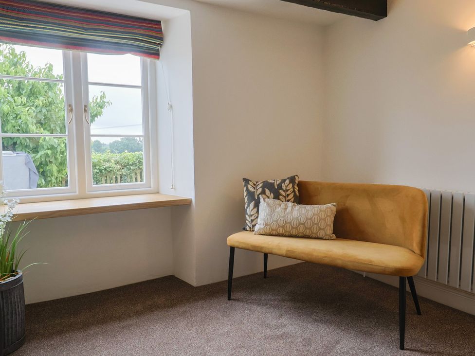 A snug with a sofa and cushions at The Old Inn in Winterborne Whitechurch
