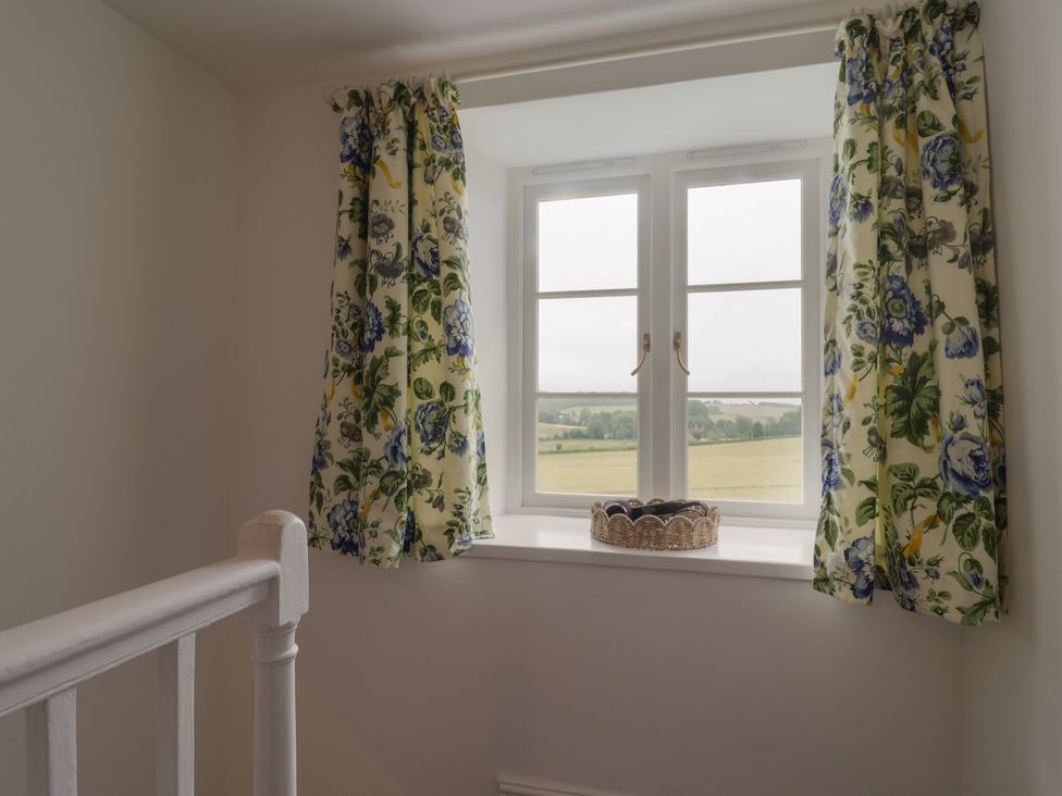 A landing with a window and curtains at The Old Inn Winterborne Whitechurch