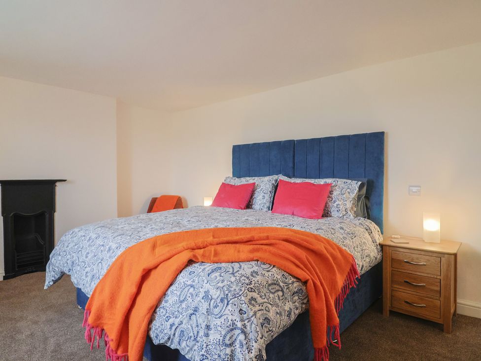 A bedroom with a large bed and bedside table at The Old Inn in Winterborne Whitechurch