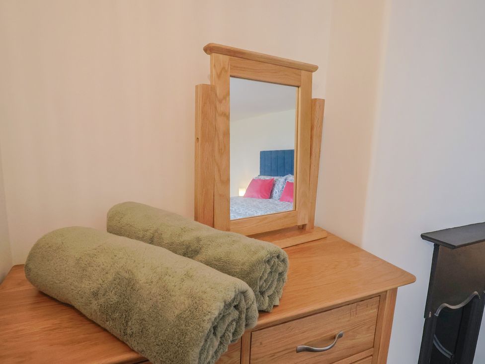 A dresser with towels and a mirror at The Old Inn in Winterborne Whitechurch