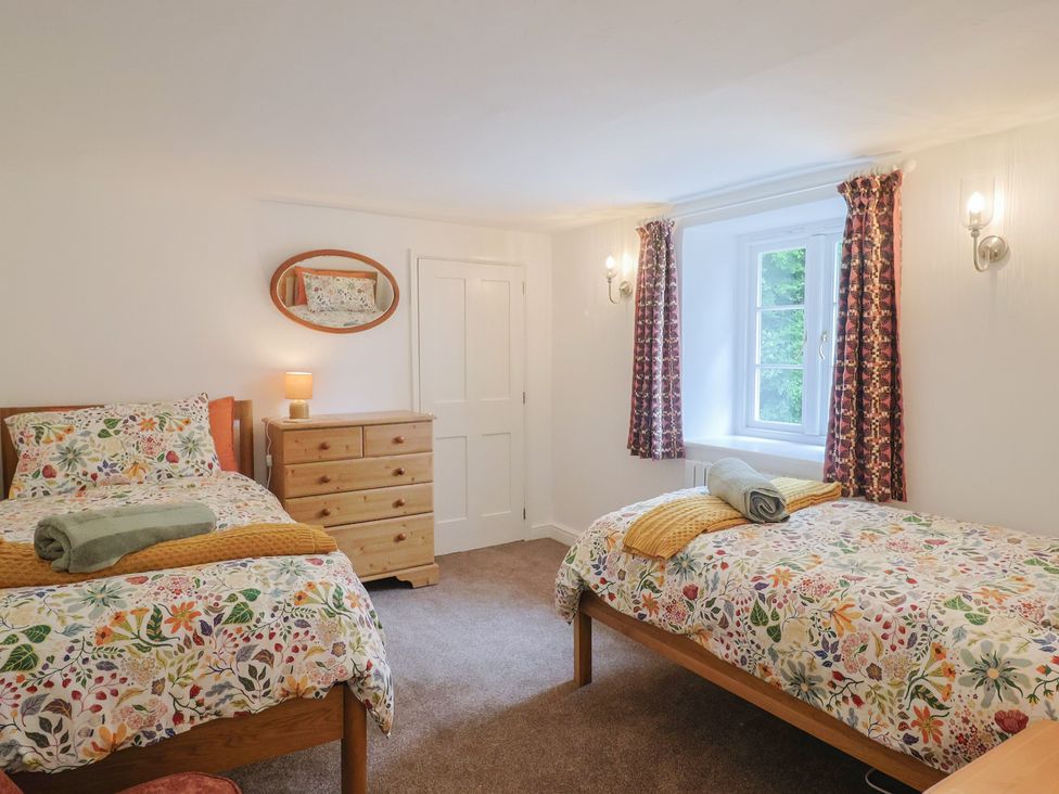 A bedroom with two beds and a dresser at The Old Inn in Winterborne Whitechurch