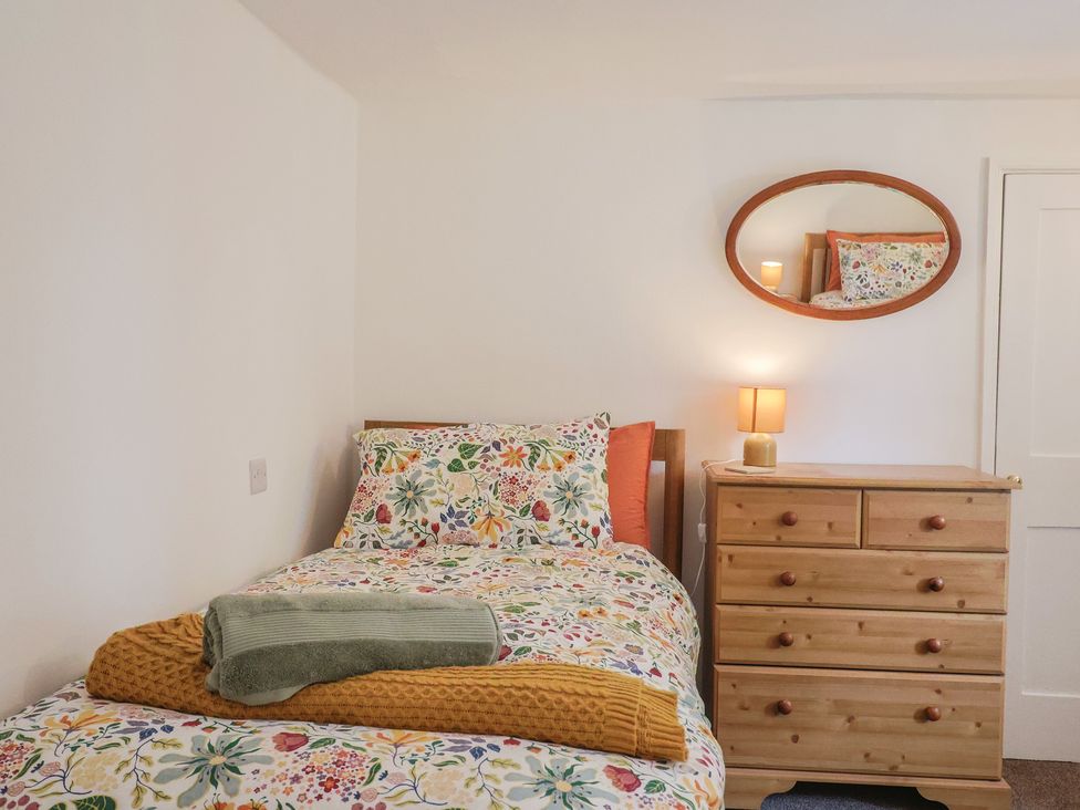 A bedroom with a bed and chest of drawers at The Old Inn in Winterborne Whitechurch