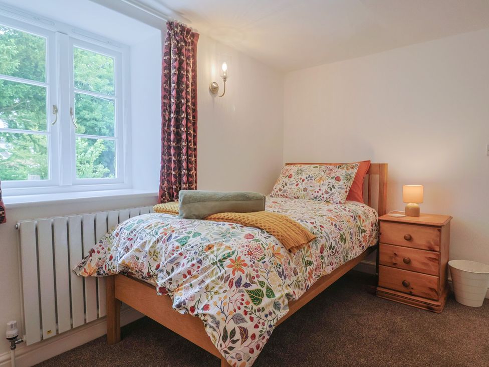 A bedroom with a bed and bedside table at The Old Inn in Winterborne Whitechurch