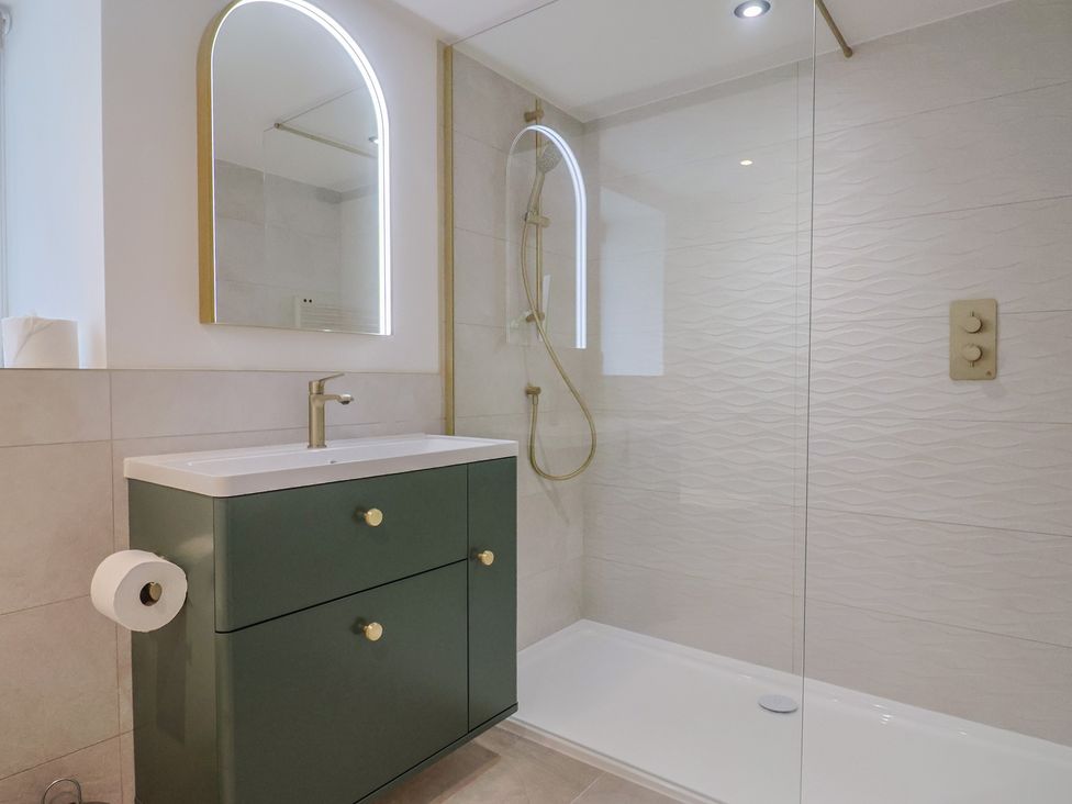 A bathroom with a shower and sink at The Old Inn in Winterborne Whitechurch