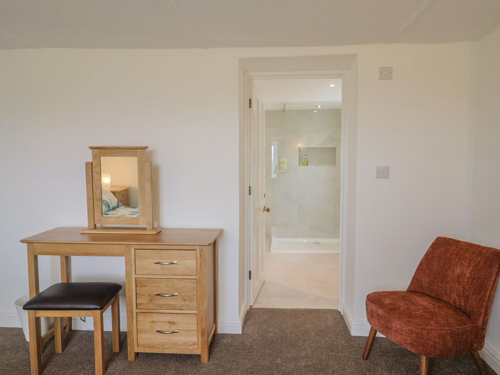 A bedroom with a dressing table and mirror at The Old Inn Winterborne Whitechurch