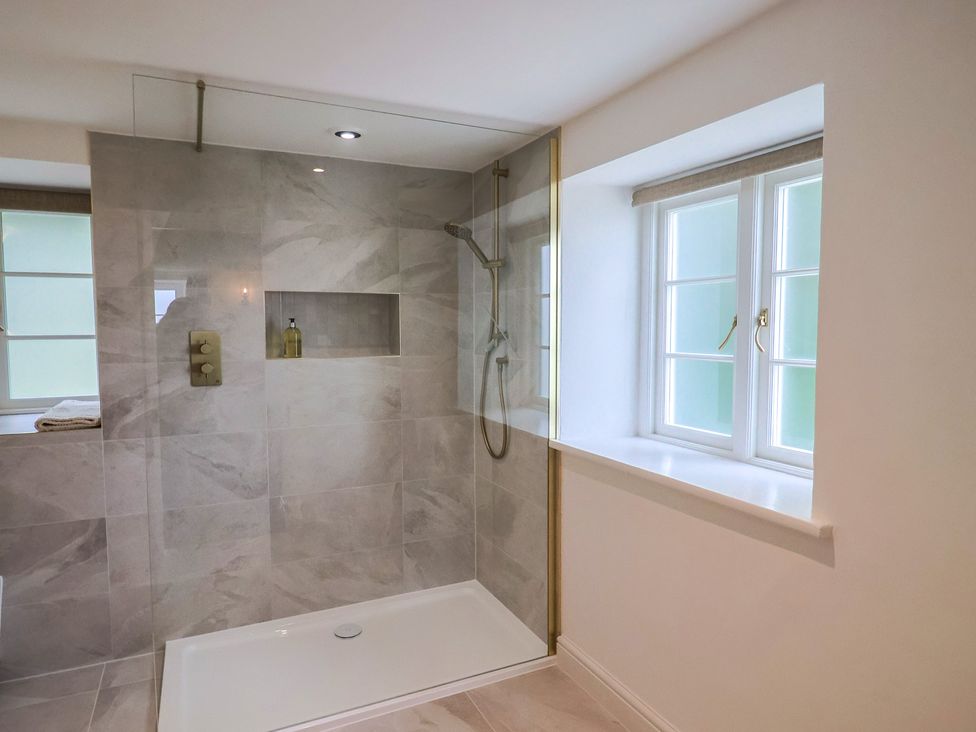 A bathroom featuring a shower with glass screen at The Old Inn in Winterborne Whitechurch