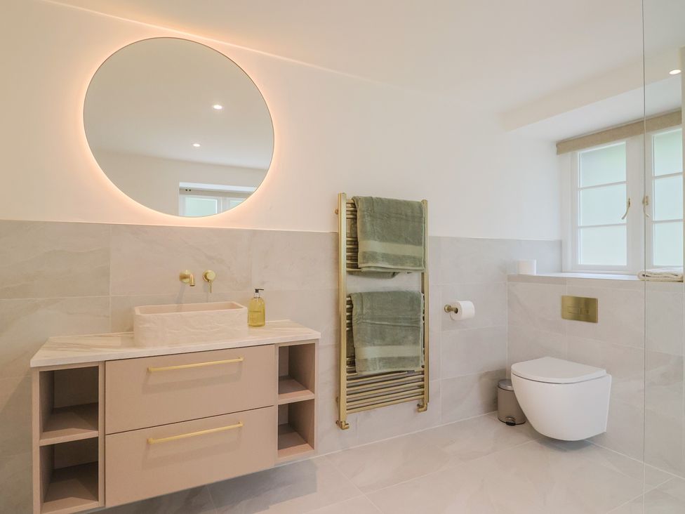 A bathroom with a sink, towel rack, and toilet at The Old Inn in Winterborne Whitechurch