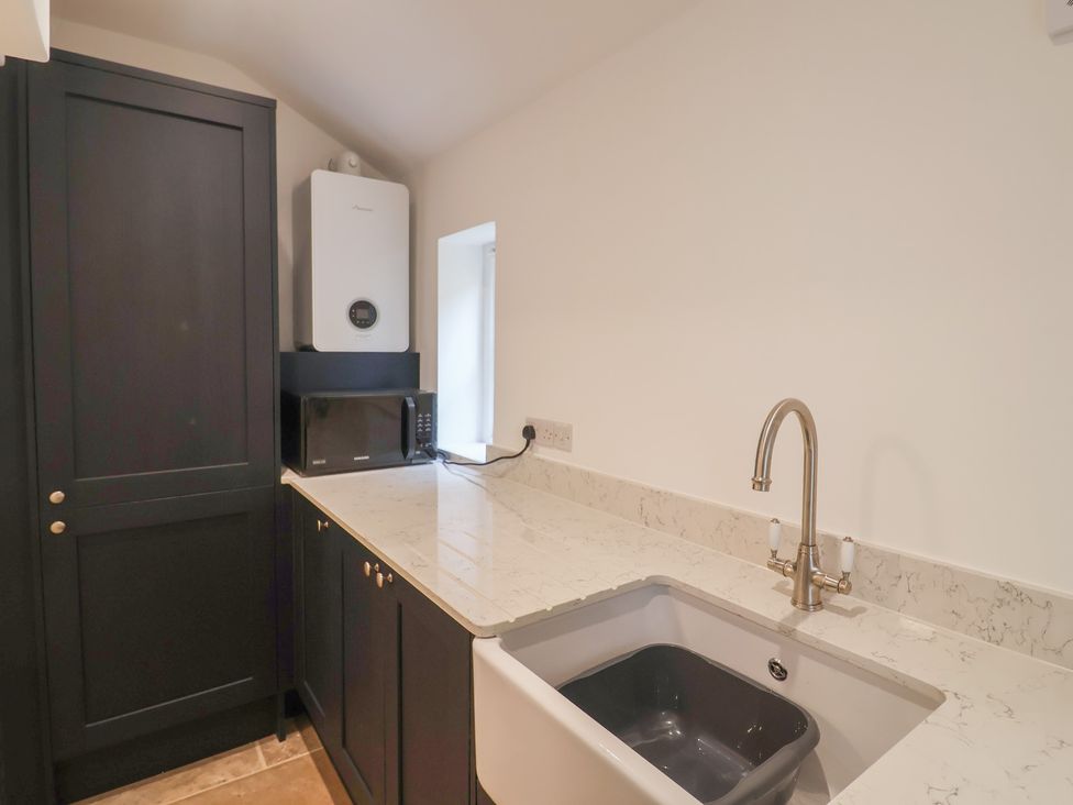 A kitchen with a sink and microwave at The Old Inn in Winterborne Whitechurch