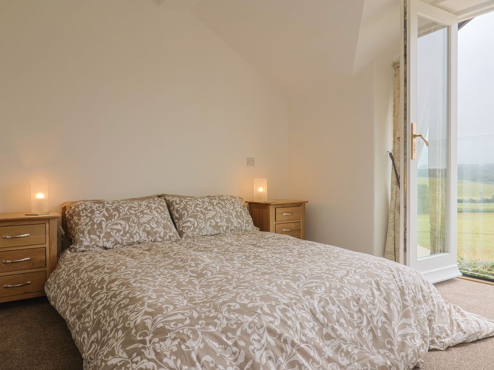 A bedroom with a bed and two nightstands at The Old Inn in Winterborne Whitechurch