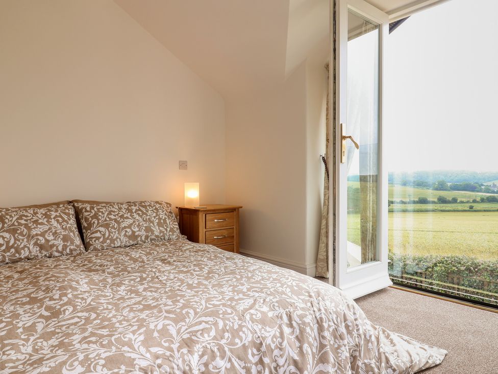 A bedroom with a bed and nightstand at The Old Inn in Winterborne Whitechurch