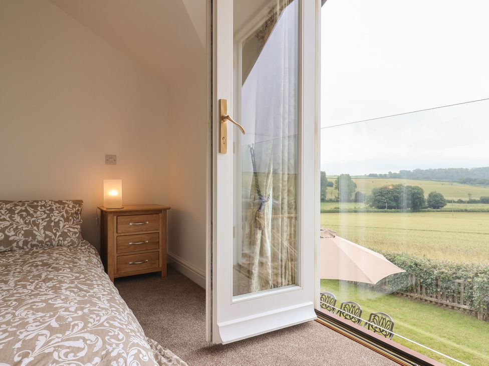 A bedroom with a bed and nightstand at The Old Inn in Winterborne Whitechurch