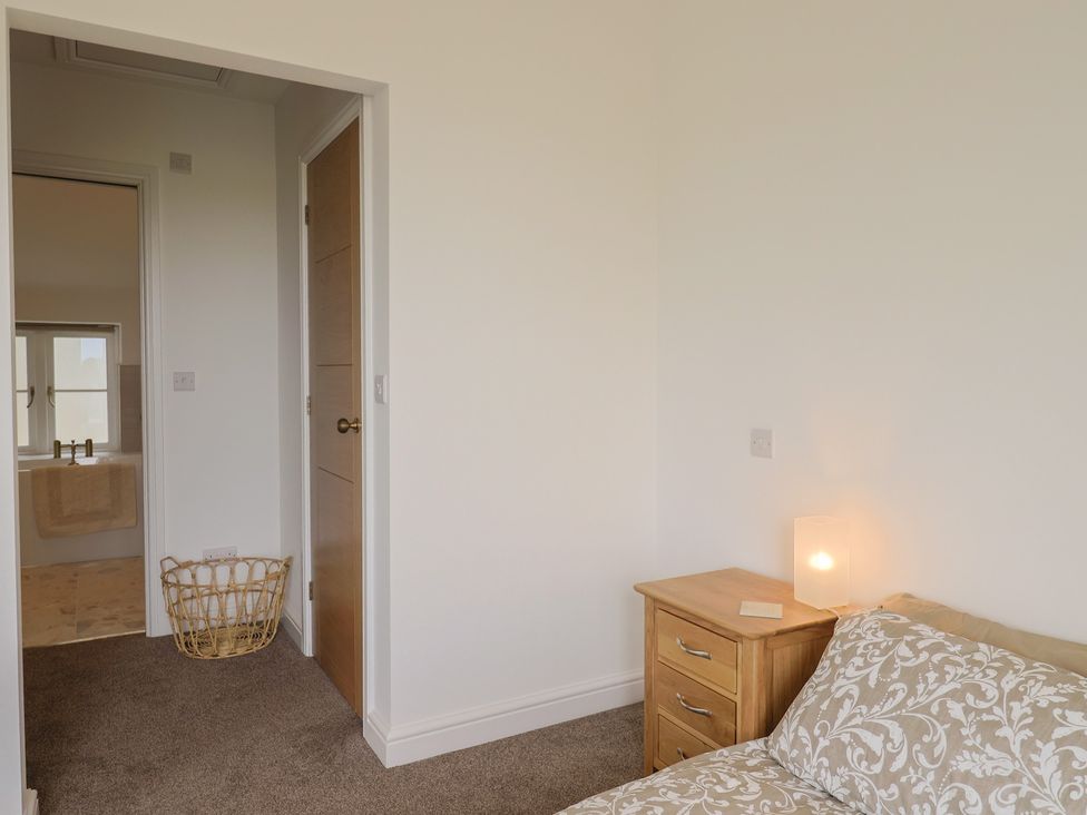 A bedroom with a bed and nightstand at The Old Inn in Winterborne Whitechurch