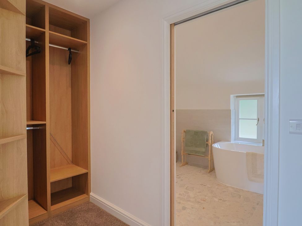 A wardrobe and a bathtub visible from a doorway at The Old Inn Winterborne Whitechurch