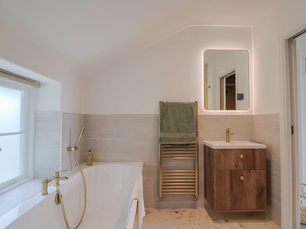 A bathroom with a bathtub and sink at The Old Inn in Winterborne Whitechurch