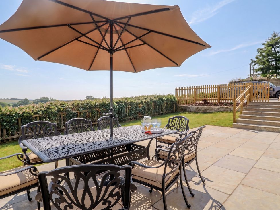 A garden with a table and umbrella at The Old Inn Winterborne Whitechurch