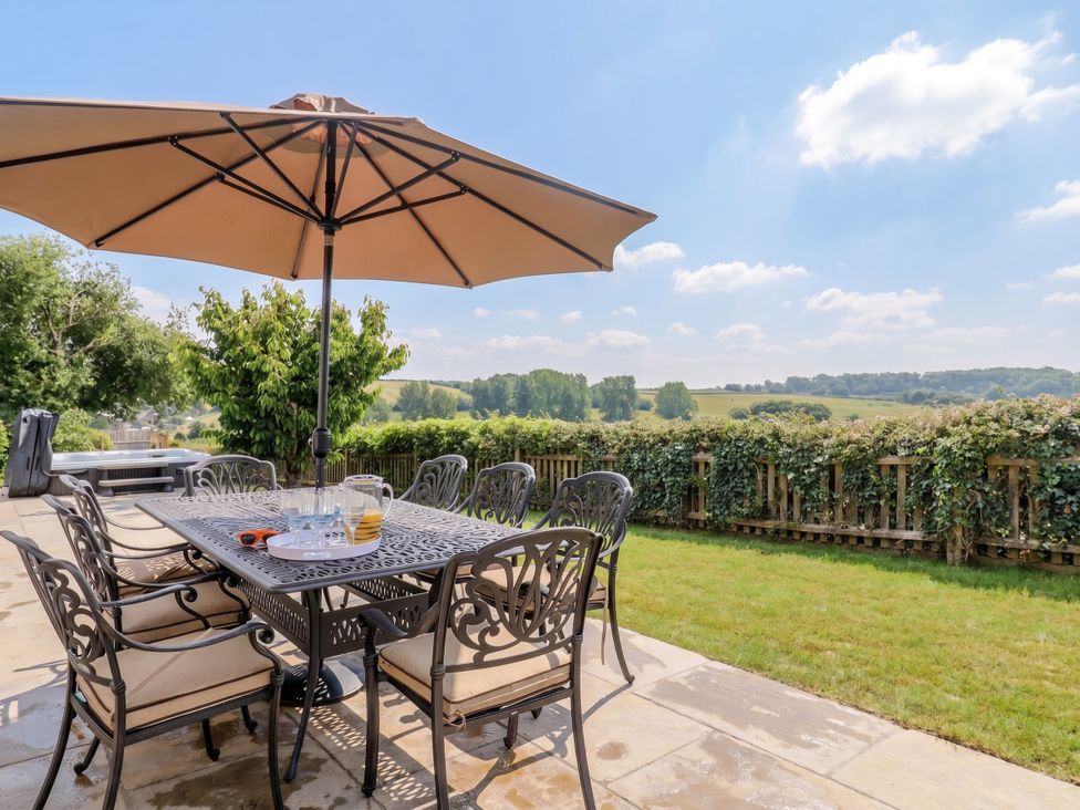 A garden with a table and chairs under an umbrella at The Old Inn Winterborne Whitechurch