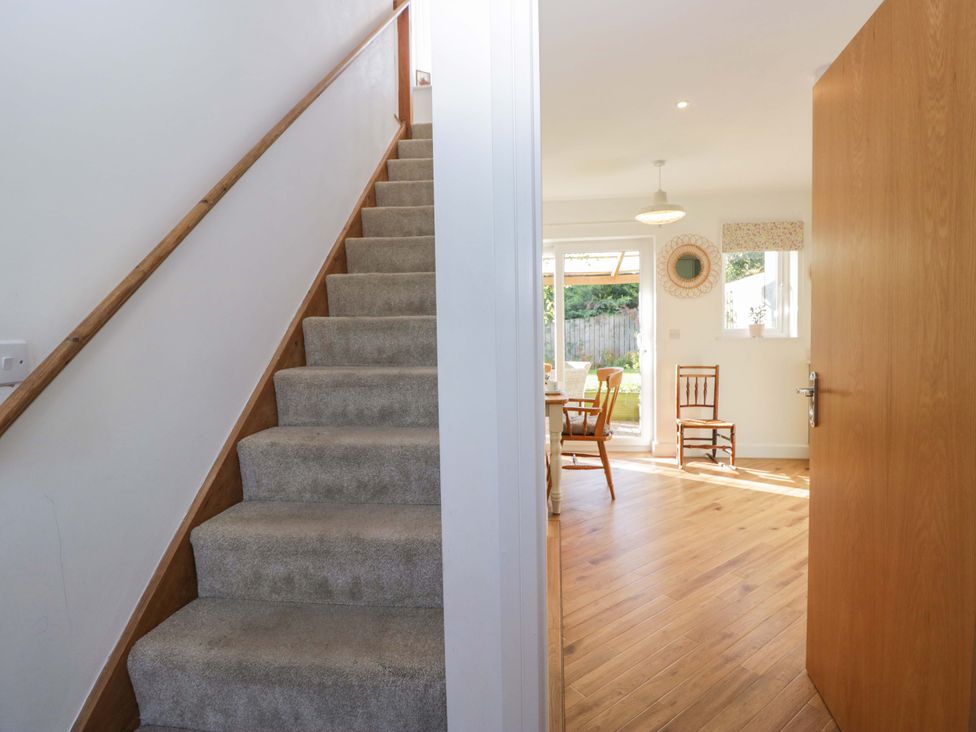 A hallway with stairs and chairs at 27 Oversands View