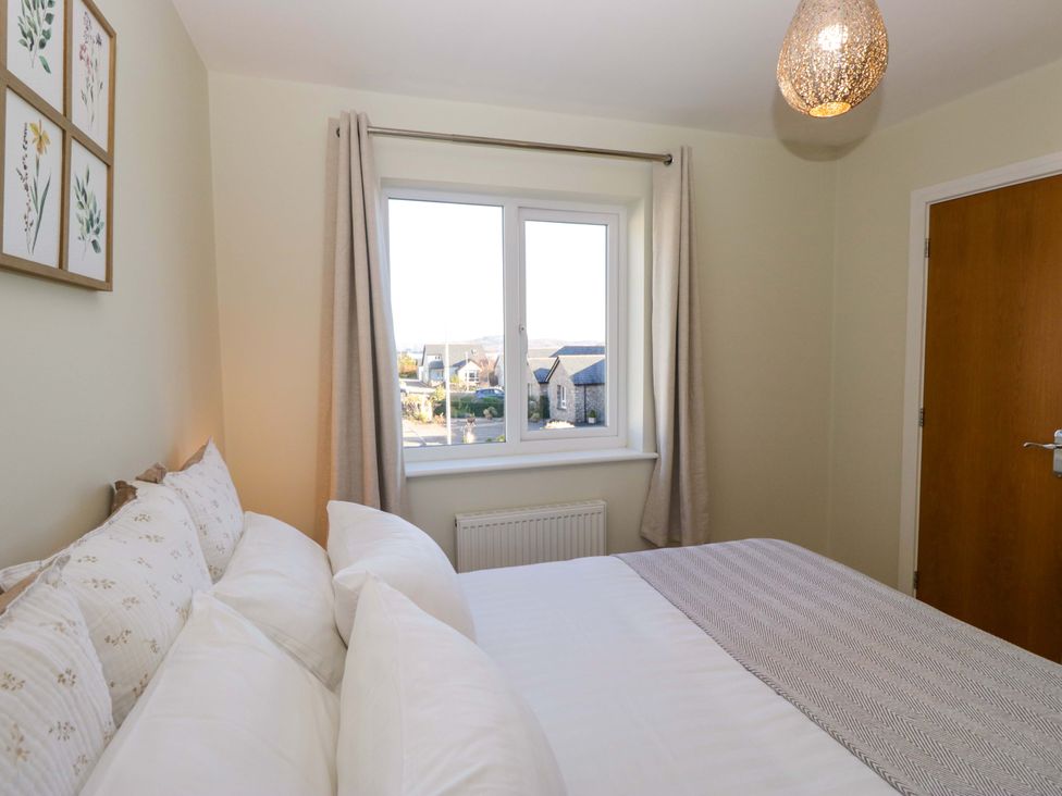 A bedroom with a bed and window at 27 Oversands View