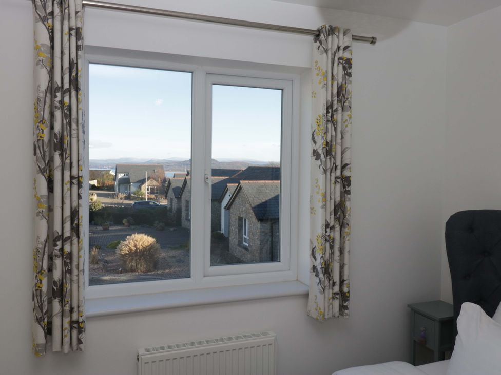 A window with curtains and a radiator in a bedroom at 27 Oversands View