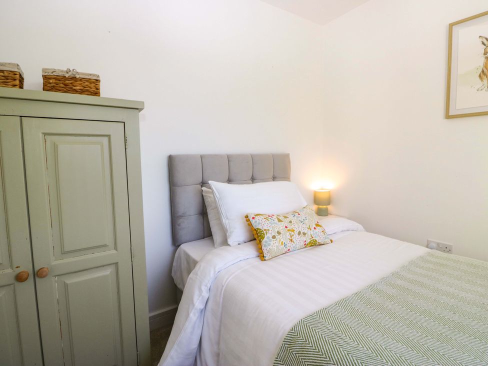 A bedroom with a bed and cabinet at 27 Oversands View