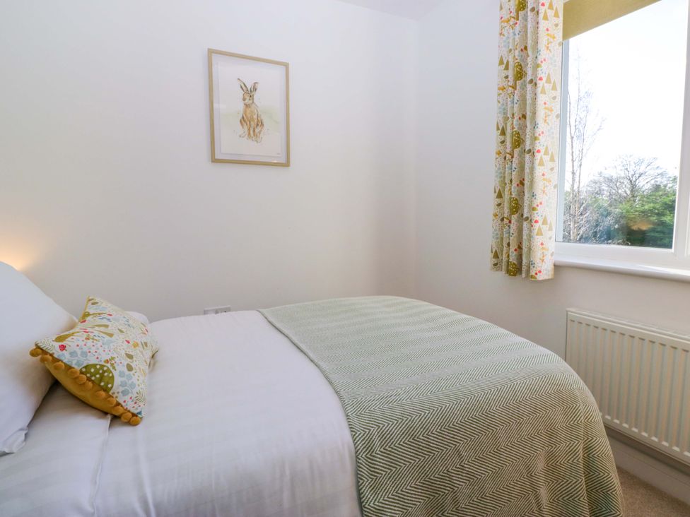 A bedroom with a bed and window at 27 Oversands View
