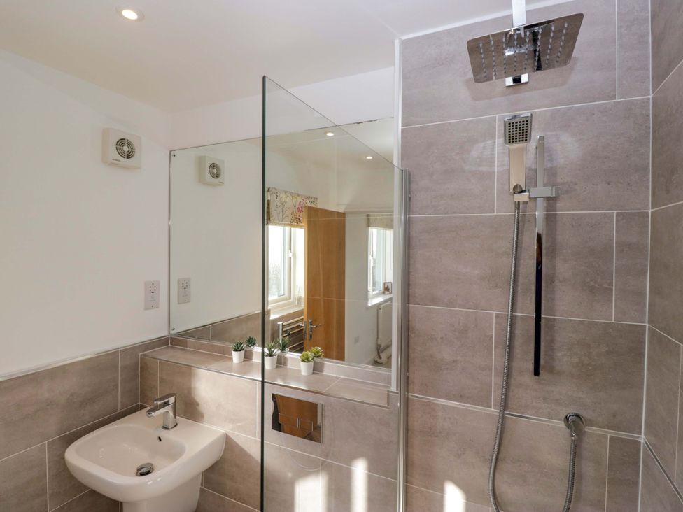A bathroom with a shower, sink and towel heater at 27 Oversands View