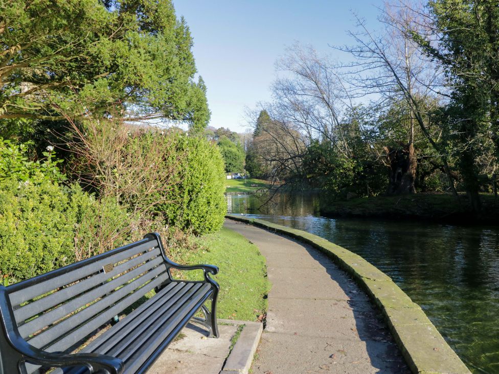A pathway beside a water body with a bench at 27 Oversands View 