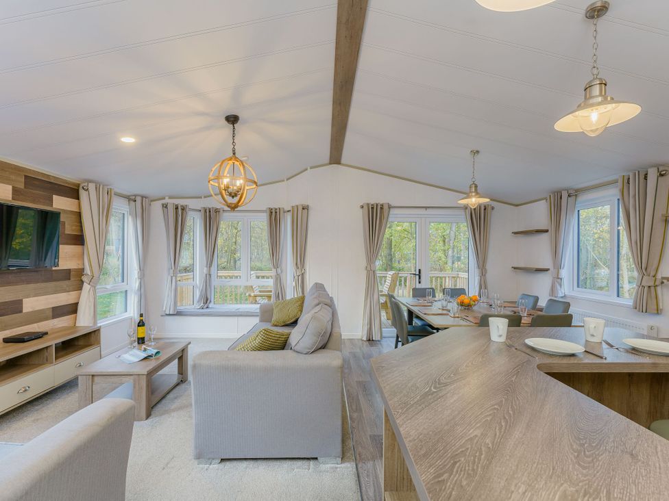 A living room with a sofa, dining table and television at Brayford Lodge (Pet) Louth