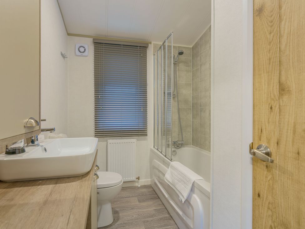 A bathroom with a sink, toilet, bathtub, and shower at Brayford Lodge (Pet) in Louth