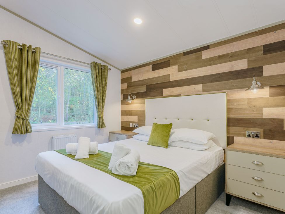A bedroom with a bed and bedside table at Brayford Lodge (Pet) in Louth