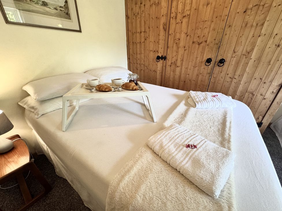 A bedroom with a tray of breakfast on the bed at Forest Break Southampton