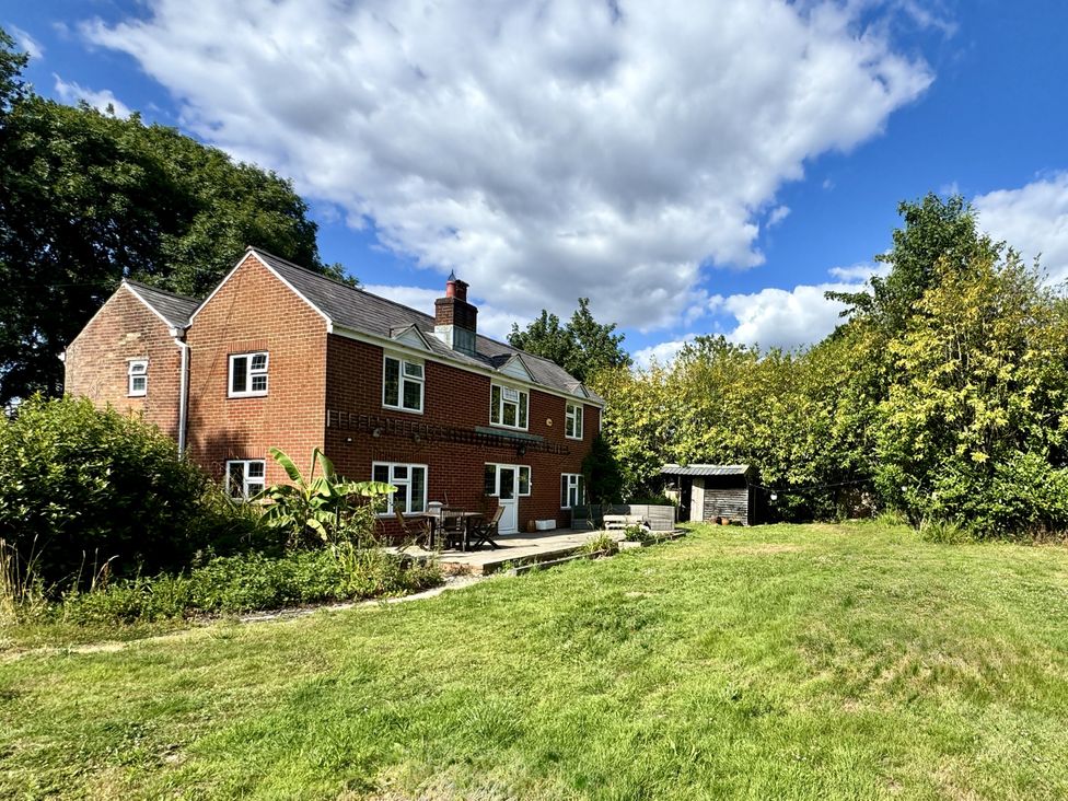 A house with patio furniture and shed in the garden at Forest Break in Southampton