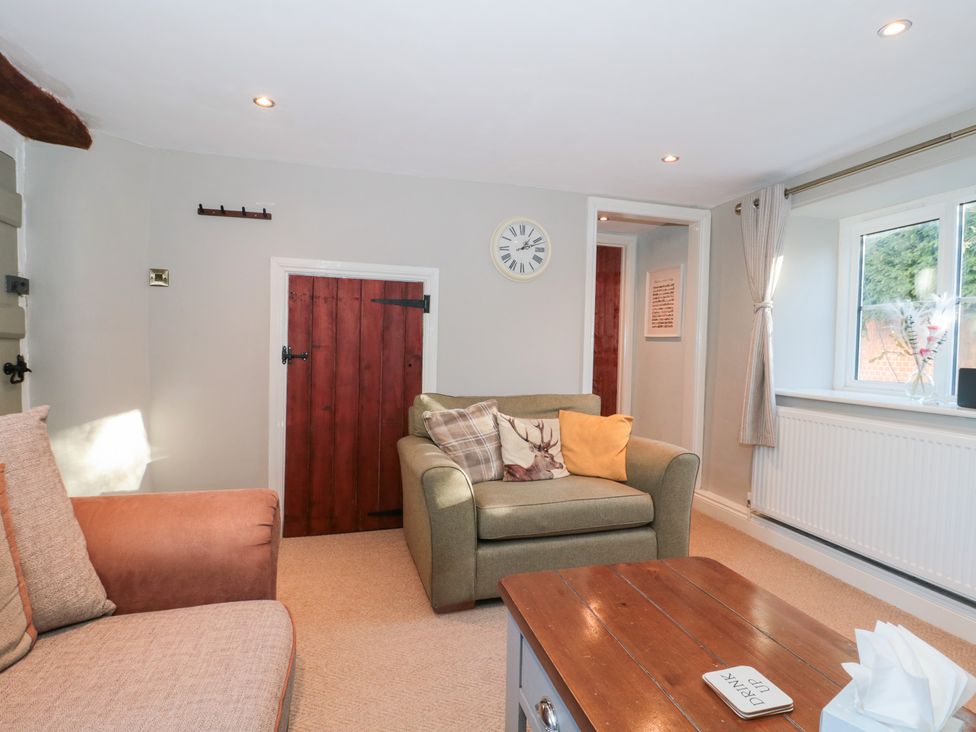 A living room with seating and a coffee table at The Corner Cottage in Gloucester