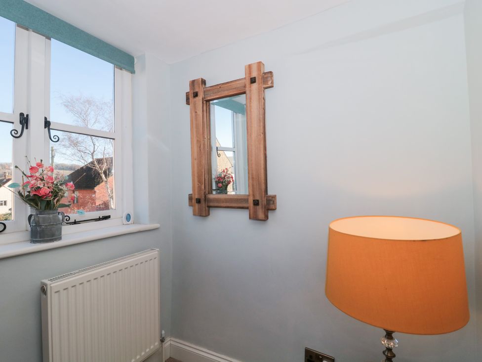 A corner with a mirror and lamp at The Corner Cottage in Gloucester