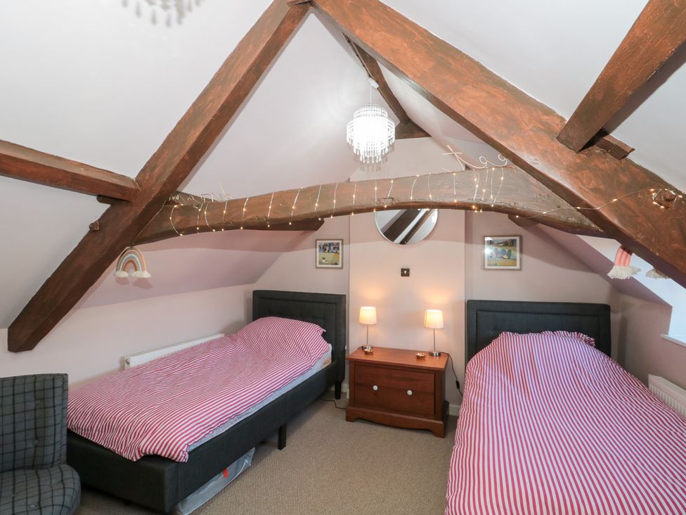 A bedroom with two beds and a chest of drawers at The Corner Cottage in Gloucester