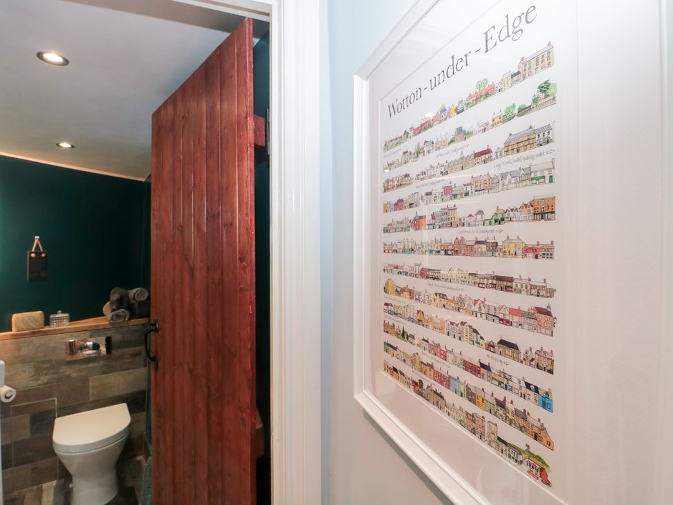 A bathroom featuring a toilet and decorative wall art at The Corner Cottage in Gloucester