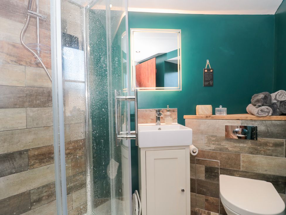 A bathroom with a shower and sink at The Corner Cottage in Gloucester