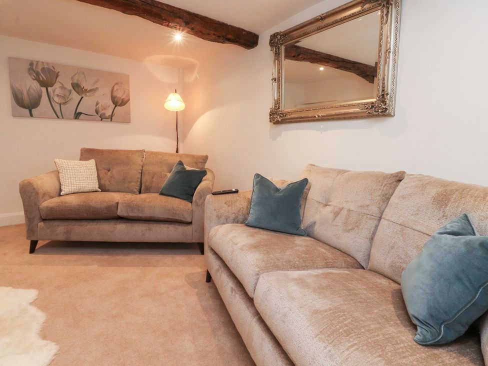 A living room with sofas and a lamp at Cobble Cottage in Clitheroe
