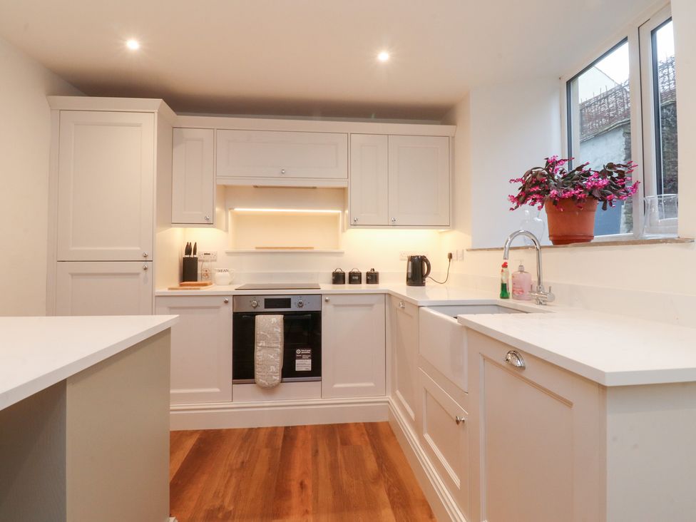A kitchen with cabinets and a sink at Cobble Cottage in Clitheroe