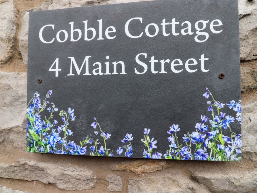 A sign displaying Cobble Cottage and 4 Main Street at Cobble Cottage in Gisburn