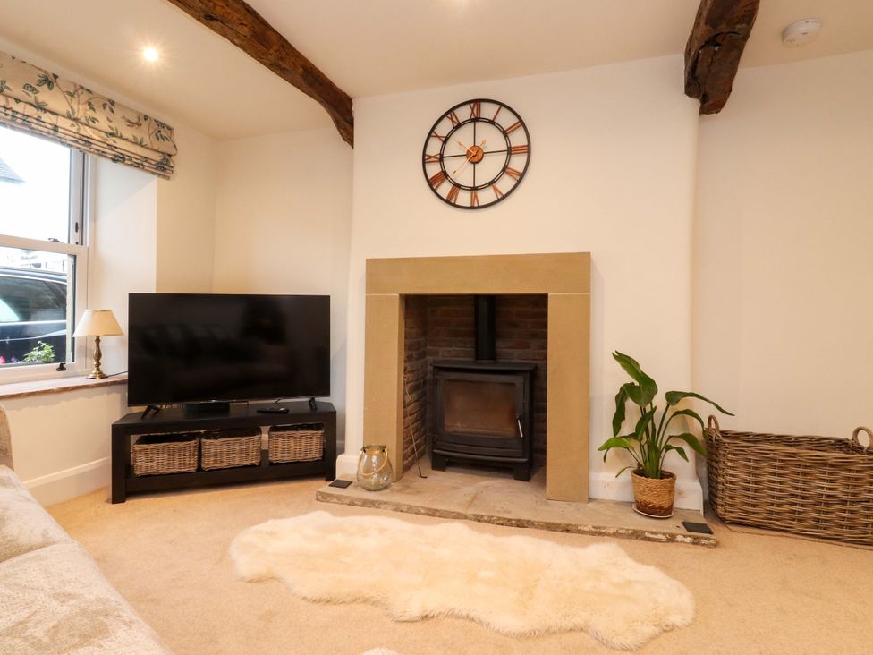 A living room with a television and fireplace at Cobble Cottage in Gisburn